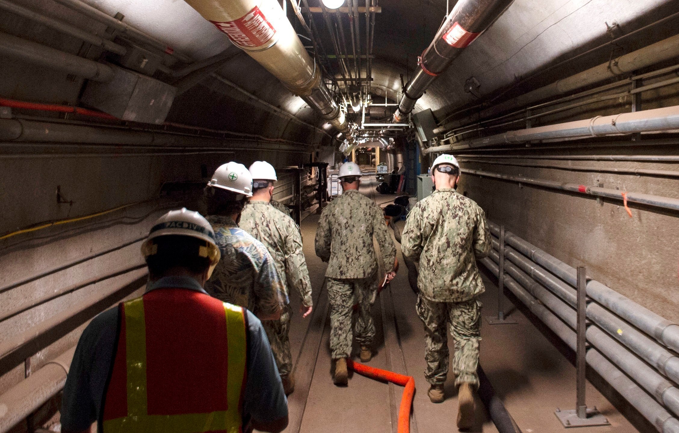 FILE - In this photo provided by the U.S. Navy, Rear Adm. John Korka, Commander, Naval Facilities Engineering Systems Command (NAVFAC), and Chief of Civil Engineers, leads Navy and civilian water quality recovery experts through the tunnels of the Red Hill Bulk Fuel Storage Facility, near Pearl Harbor, Hawaii, Dec. 23, 2021. On Thursday, Sept. 28, 2023, the Navy issued written reprimands to three now-retired military officers for their roles in the spill of jet fuel into Pearl Harbor's drinking water in 2021, but did not fire, suspend, dock the pay or reduce the rank of anyone for the incident. (Petty Officer 1st Class Luke McCall/U.S. Navy via AP, File)